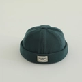 Detalle del gorro docker de punto verde oscuro con textura acanalada y etiqueta tejida - Verde Oscuro