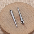 Pair of gunmetal spiked cone charms for jewelry making displayed on a wooden tray - Gunmetal