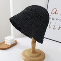 Detail of black woven straw bucket hat on wooden stand with aesthetic room decor - Black