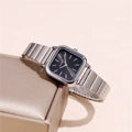 Détail d'une montre carrée argentée avec cadran noir sur un écrin en satin doré - Cadran Noir Argenté