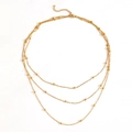 Detalle de collar triple de titanio dorado con cuentas y cierre de mosquetón ajustable - Collar de Oro