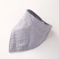 Gros plan du bavoir en mousseline de coton lilas montrant la texture douce et le bouton-pression - Gris clair