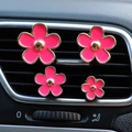 Detailed view of four pink daisy car air vent clips installed on dashboard grille - 4pcs Set + Fragrance Tablet / Rose Red
