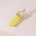 Hexagonal yellow crystal column pendant with silver metal bail on beige leather surface - Yellow Cat's Eye
