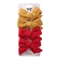 Detail of 4-pack kids fabric bow hair clips in ginger and red on a white display card - Ginger Yellow & Red