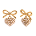 Vintage gold bow earrings with pearl-encrusted heart pendants on a white background - Pearl Heart Pendant Bowknot Style / Gold