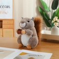 Peluche realistico di scoiattolo con ghianda su tavolo in legno in ambiente accogliente - Scoiattolo / 25cm