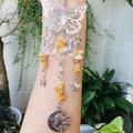Detail of silver suncatcher with butterfly, moon, and sun charms with crystal beads - Topaz