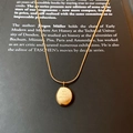 Detail of gold titanium necklace with 'you are adorable' engraved oval pendant on a book - Gold Engraved Round Tag