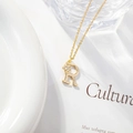 Detail of gold letter R necklace featuring a small flower with sparkling zircon stone - Letter R