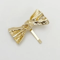 Detalle de un gancho para el pelo de metal dorado con un acabado texturizado - Dorado
