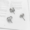 Three minimalist C-shaped metal hair clips in polished silver finish on a book - Semicircle Three-Piece Set / Silver