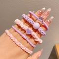 Pink and purple elastic hair ties set with heart charms held by hand for little girls - Purple Series