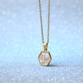 Gold hexagon shell necklace featuring letter L pendant on sparkling blue background - Letter L