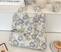 Detailed view of floral canvas tote bag with butterfly patterns and brand woven label - Blue Floral