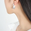 Silver earring with irregular hollow texture and a white pearl on a model's ear - Silver Earrings