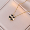 Detailed macro of a gold four-leaf clover pendant with black zircons on silk lining - Black Heart Clover (Gold Chain)