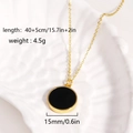 Elegante collana dorata con pendente nero tondo esposta su un vassoio a forma di conchiglia - Collana