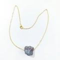 Detail of a natural purple fluorite crystal pendant on a gold chain necklace - India Agate