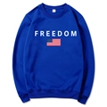 Détail du sweat bleu roi montrant l'imprimé FREEDOM blanc, drapeau US et étiquette taille M - Bleu