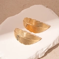 Detailed close-up of gold metal feather earrings with fine textures on a stone pedestal - Gold Leaf Stud Earrings (Silver Earring Post)