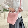 Close-up of pink plush bucket bag made of soft faux fur with long shoulder strap - Pink