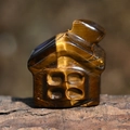 Vista macro di una casa in cristallo occhio di tigre scolpita a mano con toni dorati - Occhio di tigre
