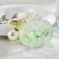 Detail of green acrylic television keychain with flowing liquid sand and gold pearl charm - Noctilucent TV Style / Green