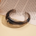 Brazalete abierto de acrílico retro con textura de mármol marrón, vista de 45° - Mármol Negro Ahumado