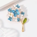 Squisita spilla a forma di ortensia in smalto con strass e foglia verde su base oro - Blu + Bianco