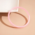 Nahaufnahme eines rosa marmorierten Acryl-Armreifs auf braunem Hintergrund, Harz-Armband - Rosa
