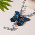 Dettaglio macro del ciondolo a farfalla ricamato con perline e cristalli colorati - Collana di perle a farfalla blu