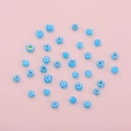 Blue flower shaped glass beads for DIY jewelry making on a pink background - Lake Blue