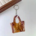 Detail view of marble-patterned acrylic handbag keychain with gold metal ring and chain - 4# Texture Brown
