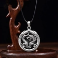 Silver dragon round necklace pendant on black cord displayed on dark wooden stand - Double Dragon + Coiled Dragon Pendant (50cm Black Rope)