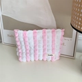 Macro detail of pink seersucker striped makeup bag showing puffy texture and Sozakka label - Bubble Pink White