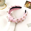 Close-up of pink fabric headband with faux pearls and champagne rhinestones on a tray - Light Pink