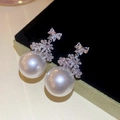 Macro-opname van fonkelende zirkoon strik en elegante witte parel op zwart fluweel - 51# Zilveren Naald - Zilver - Wit
