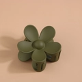 Gros plan détaillé d'une pince à cheveux fleur vert foncé avec une finition mate - Vert olive