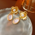 Detalle macro de pendientes vintage florales con piedras rosas y perlas en vidrio - Dorado / Rosa (Pin de Plata 925)