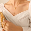 Elegante goudkleurige titaniumstalen Y-ketting met D-letter hanger gedragen door model - Letter D Stijl / Goud