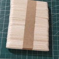 Natural wood popsicle sticks for DIY crafts bundled with brown paper on a green grid mat - Chamfered Wood 80mm*13mm*2mm