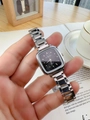 Close-up of a luxury square black dial watch with silver steel strap on a wrist - Black