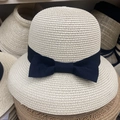 Primer plano detallado de la textura de paja y lazo de cinta negra en el sombrero - Estilo Lazo / Beige