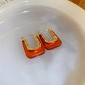Detailed shot of U-shaped gold metal and amber acrylic resin geometric earrings on a plate - U-Shape Red Style (37#)