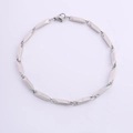 Detalle de una pulsera de acero inoxidable plateado con eslabones geométricos y cierre de mosquetón - Cadena de Semilla de Melón / Plateado