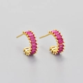 Close-up of golden C-shaped hoop earrings with sparkling pink rectangular zircons - Gold/Red Corundum