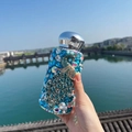 Μπλε μπουκάλι με στρας παγώνι και ασημί καπάκι που κρατιέται με φόντο τη λίμνη - 260ml / Μονωμένο ποτήρι / Μπλε