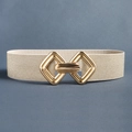 Détail d'une ceinture élastique dorée champagne avec une boucle géométrique entrelacée - Style élastique / Beige Holographique