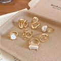 Detailed macro view of gold-plated rings set featuring organic textures and pearl accents - Gold (7-Piece Set)